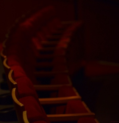 A row of red theater seats in low light.