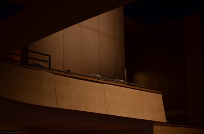 Photo of a modern balcony inside of a darkened theatre.