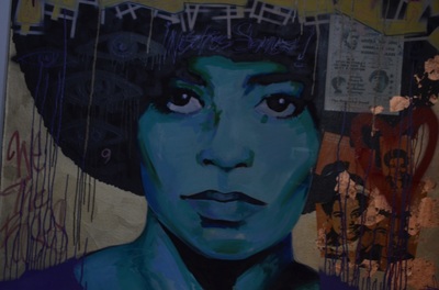 A blue-hued street art image of Angela Davis